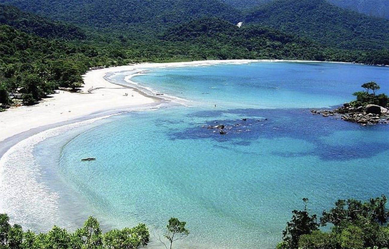 Vista aérea da Praia de Castelhanos, em Ilhabela, com o mar azul-turquesa da baía