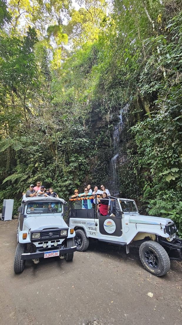 Jipes da Castelhanos Turismo parados diante de uma cachoeira