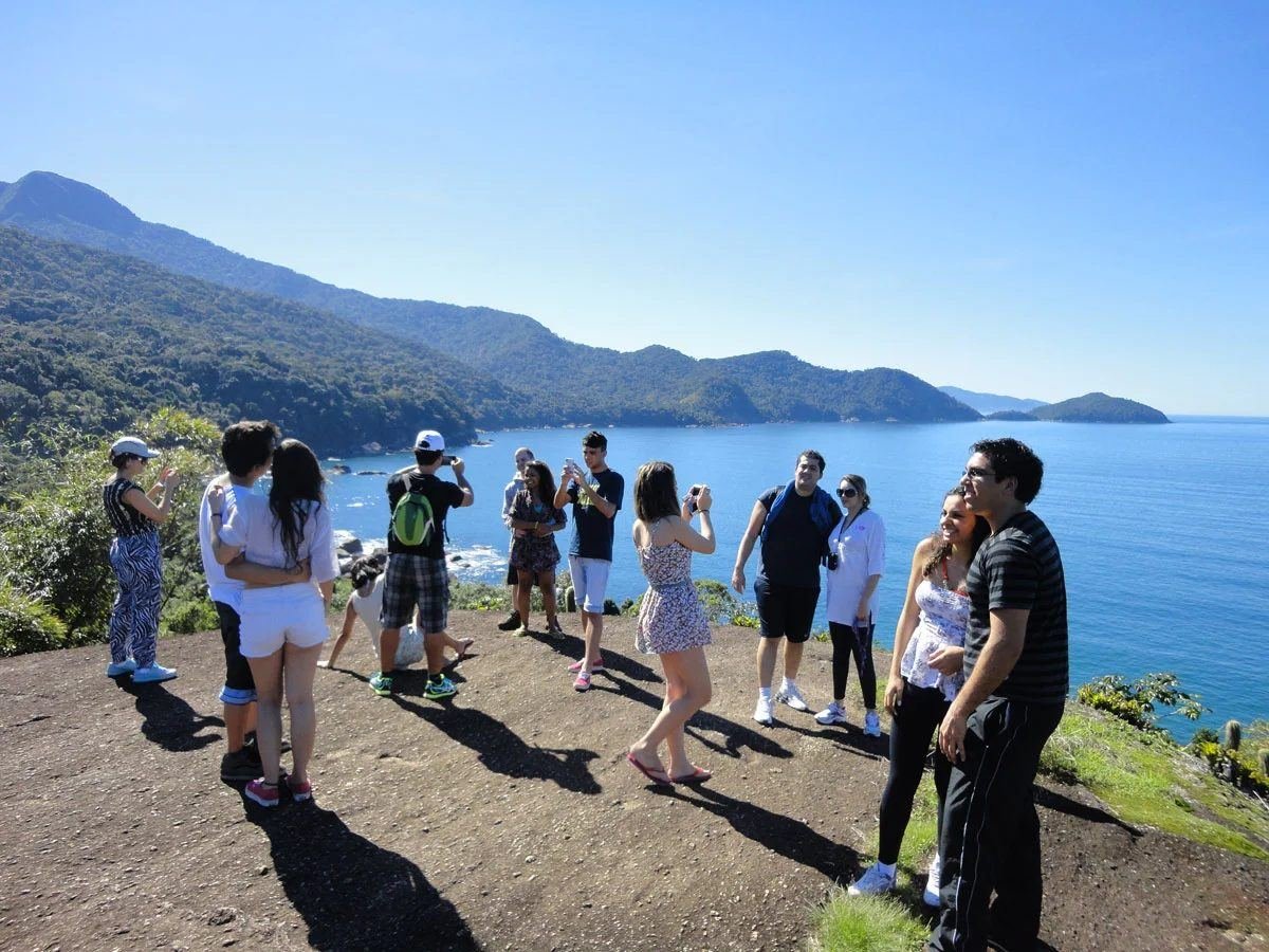 Grupo de visitantes em um mirante olhando a costa de Ilhabela