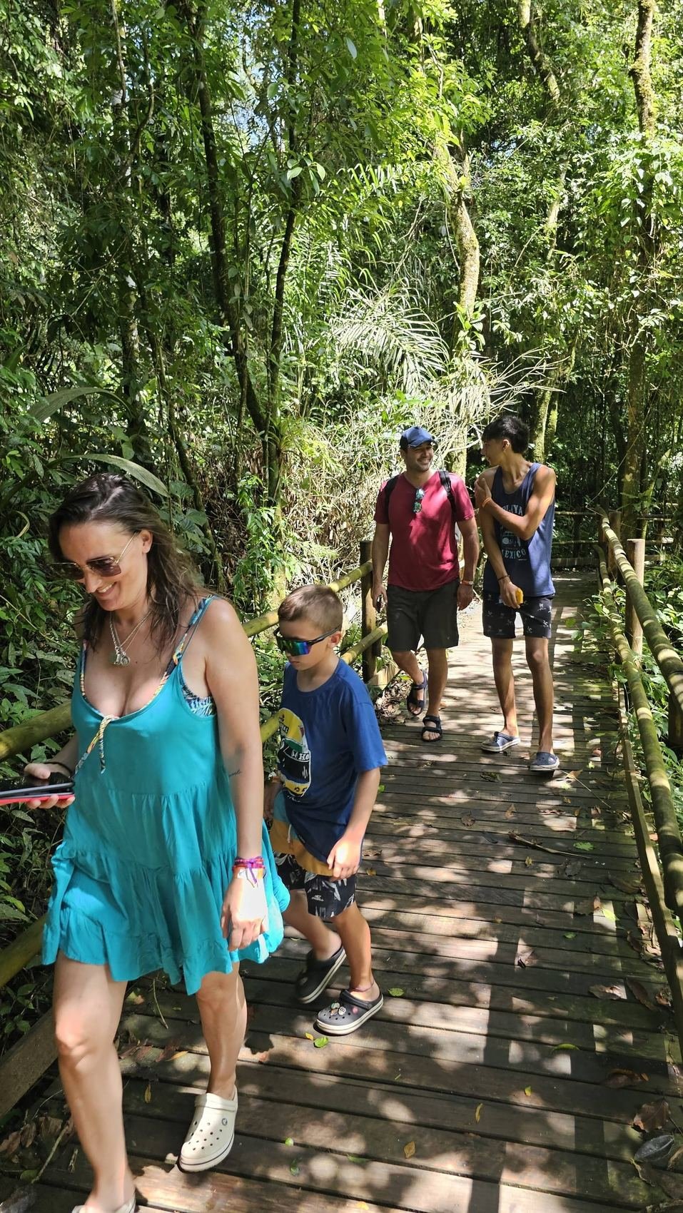 Grupo atravessando passarela de madeira na Mata Atlântica de Ilhabela