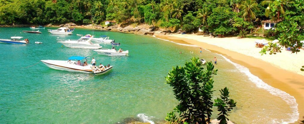 Praia da Fome com lanchas ancoradas em água esverdeada