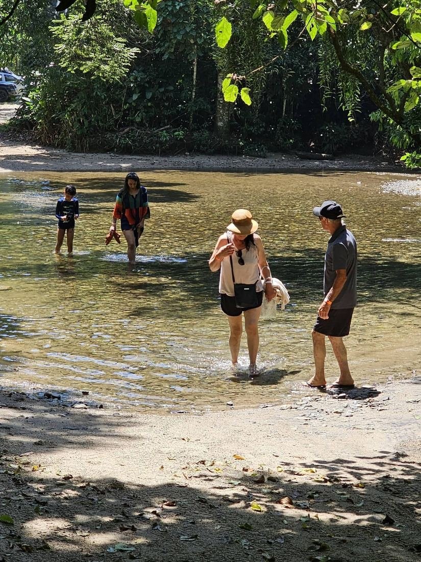 Visitantes em um rio de águas rasas em Ilhabela
